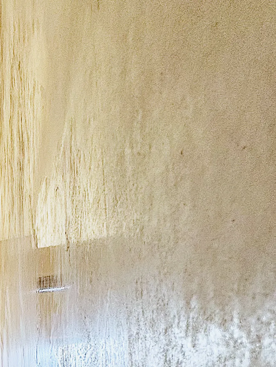 A cured MABTerra DanaLux wall with low light raking down its length, picking up the hand-trowelled sheen.